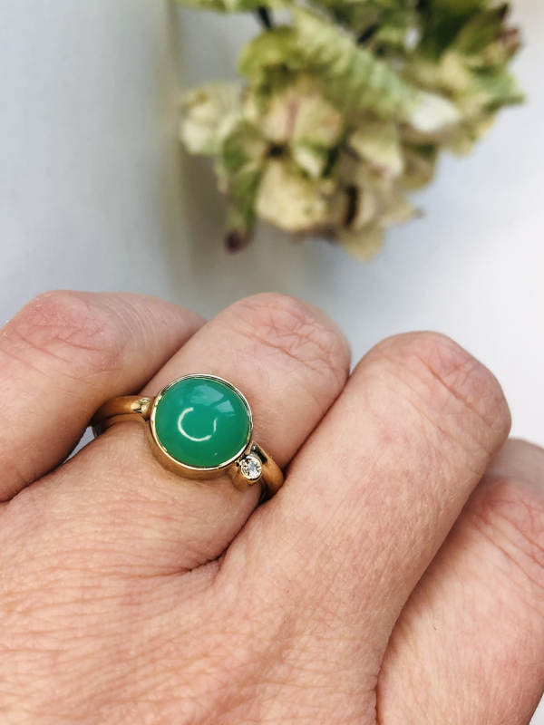 Guldring med grøn chrysophras på finger