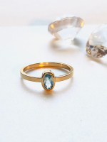 Guldring med oval lyseblå sten