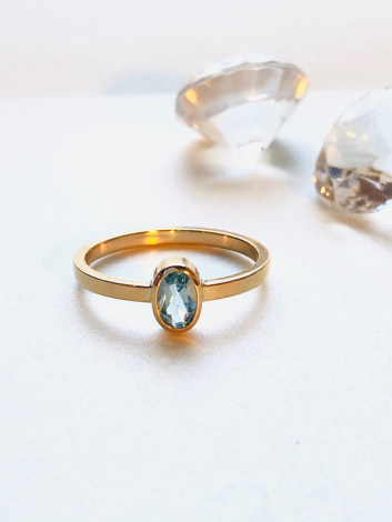 Guldring med oval lyseblå sten
