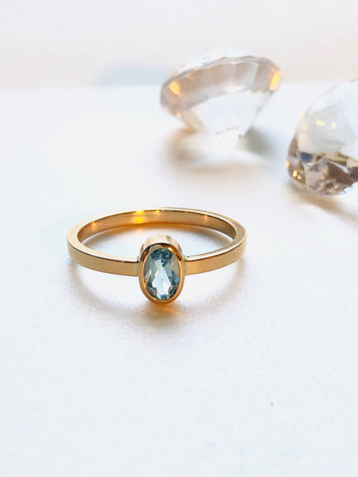 Guldring med oval lyseblå sten