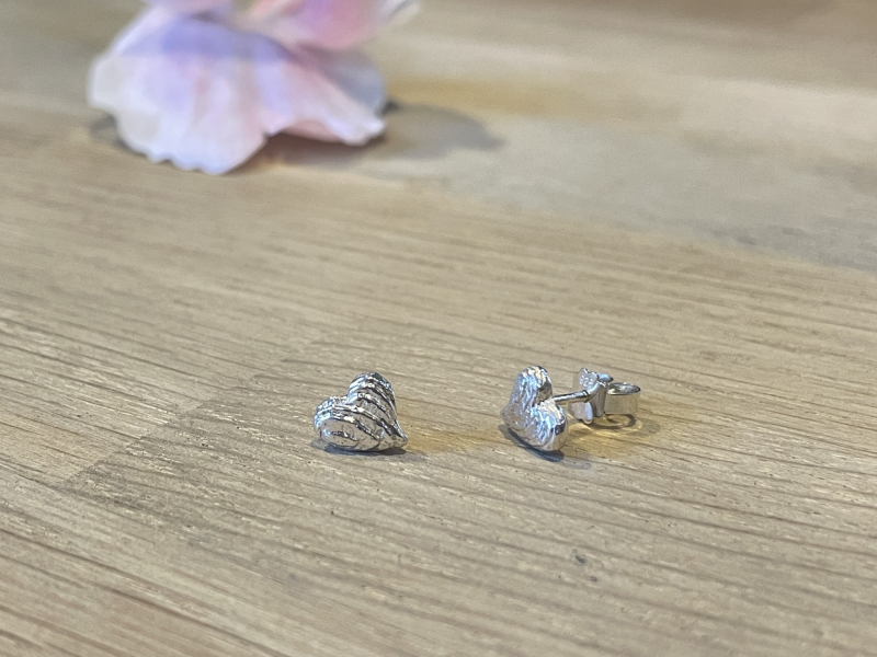 Sepia hjerteørestikker i blank sølv set fra siden