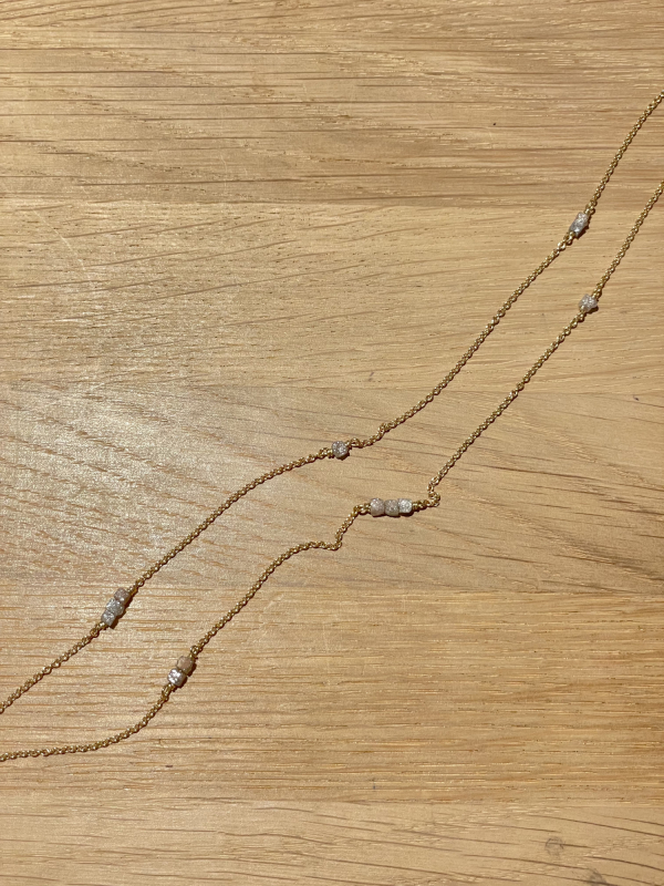 Guldkæde med rådiamanter på bordplade