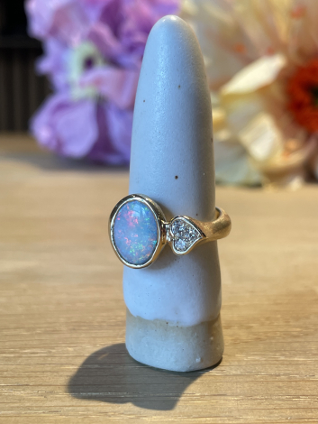 Guldring med opal på holder fra siden